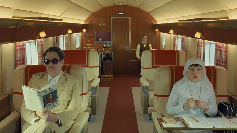 Korda, Liesl and Bjorn sitting in a plane. Everyone seems to be calm and minding their own business.