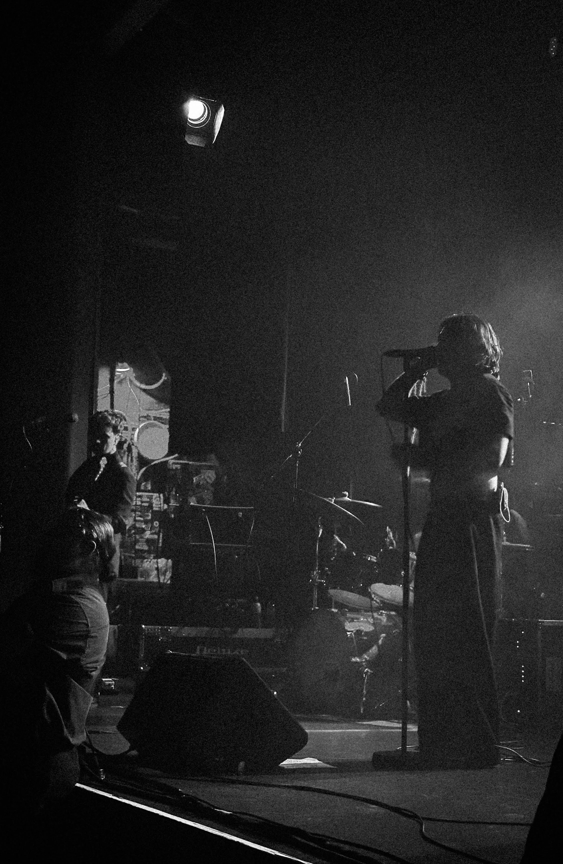 EXTREMELY crunchy black and white photograph of static dress members george holding, sam ogden and olli appleyard performing on stage.
