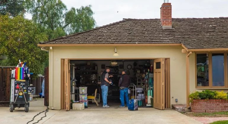 Two guys setting up a film set in a garage