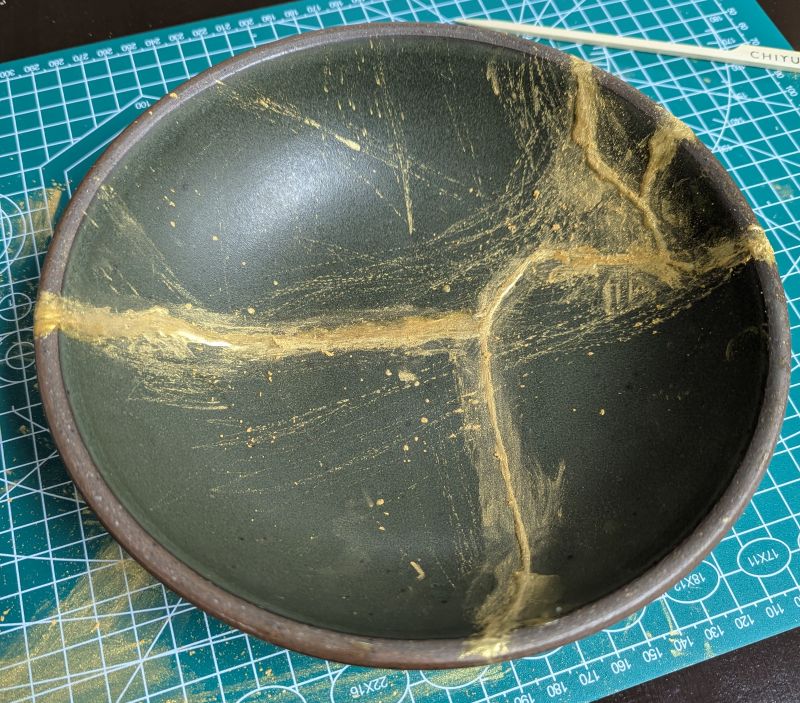 The reassembled bowl, covered in streaks of glue and powder.