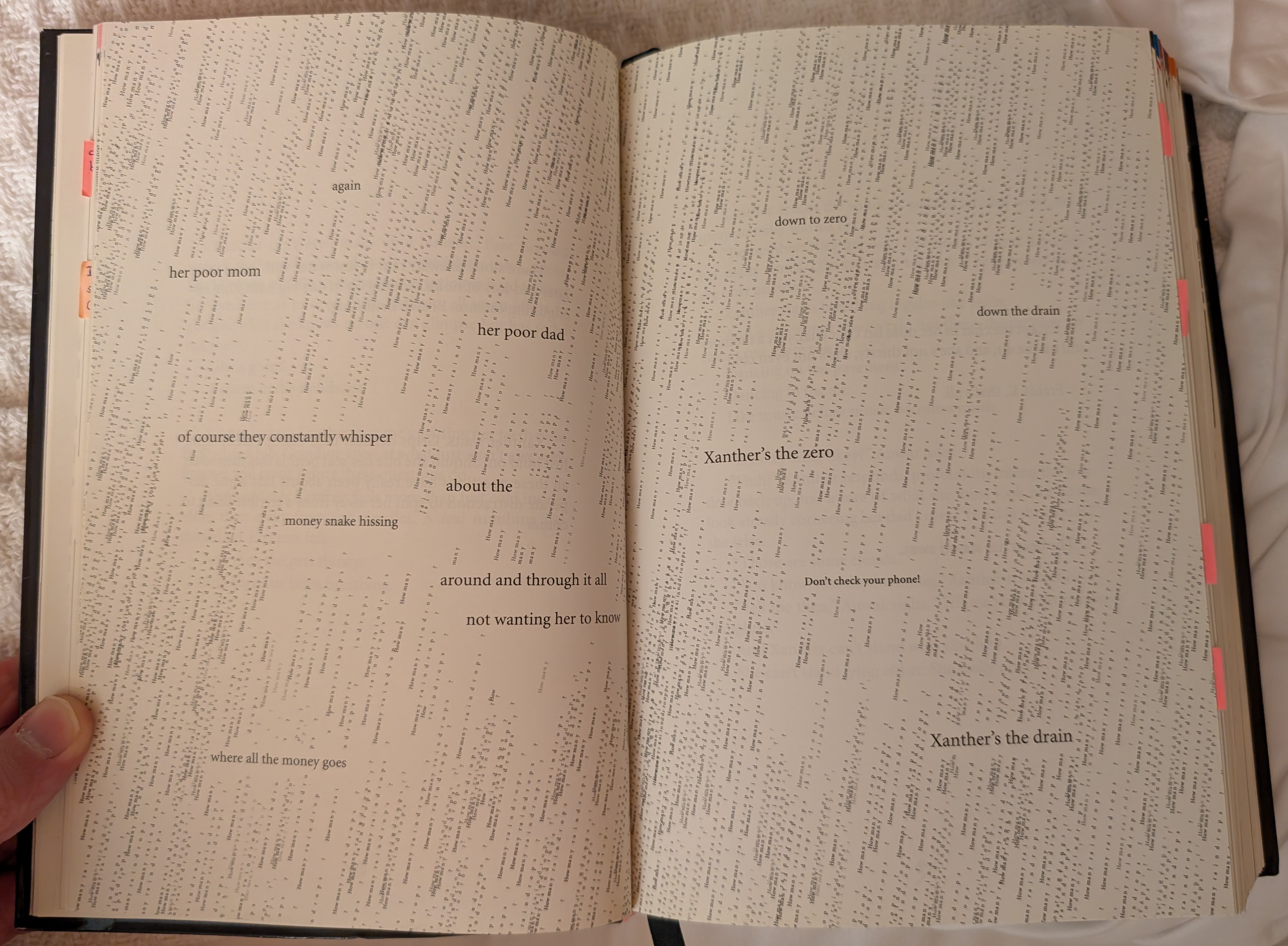 A pair of pages with fewer than fifty words of narrative, surrounded by the same repeated sentence—"How many raindrops?"—stylized to look like rain