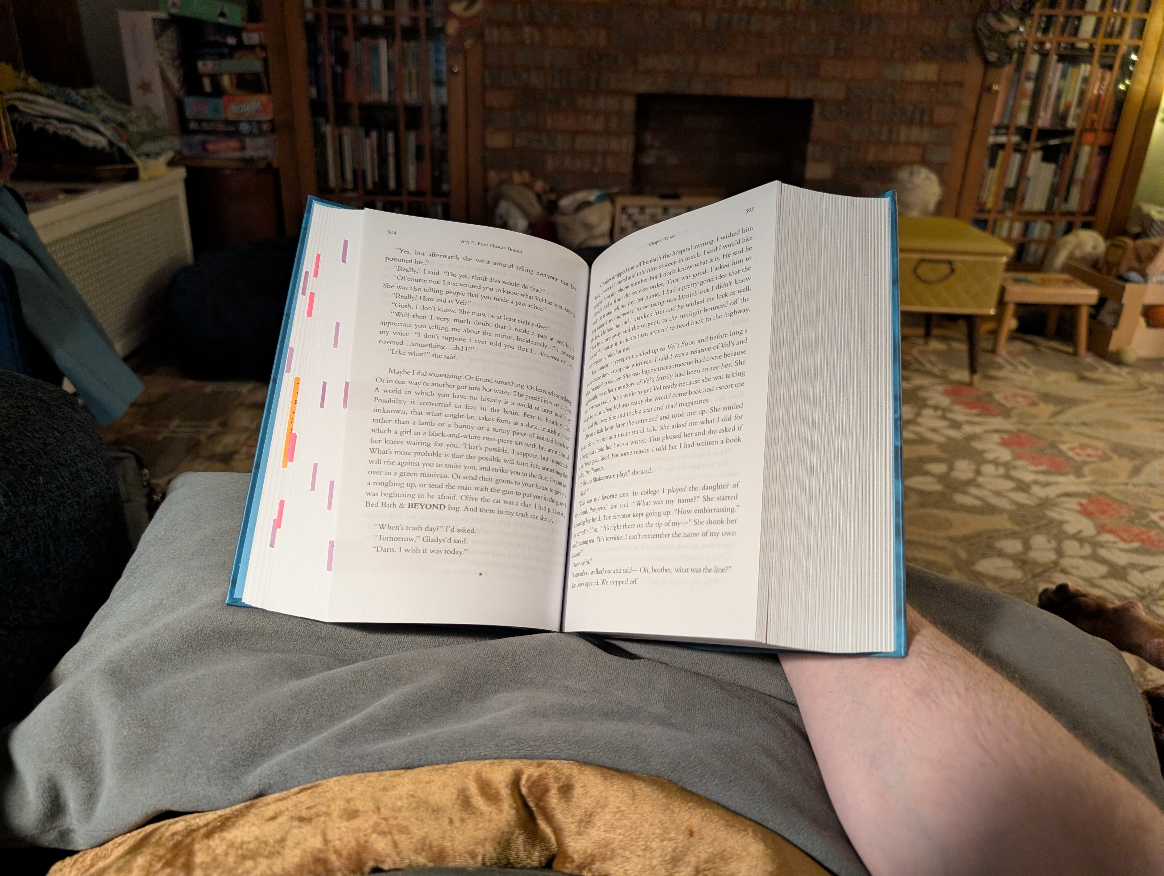 Book open and resting on a pillow, with its spin propped by my hand