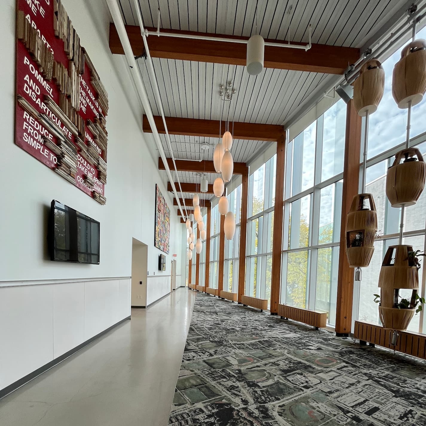 Foyer with artwork, windows, and interesting patterned carpet.