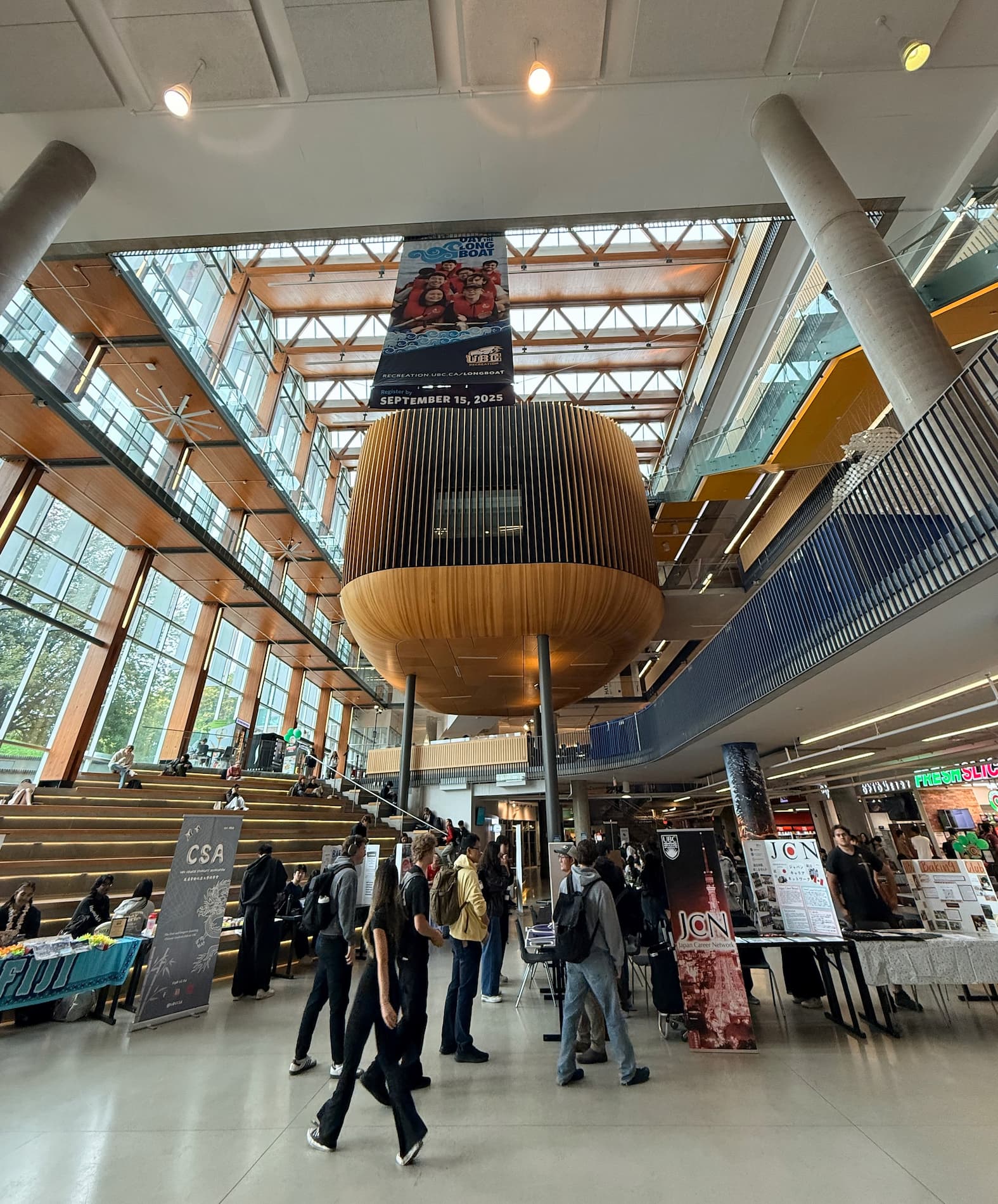 The lobby atrium of The Nest building with sweeping stairs going up and the wood feature of the landing.