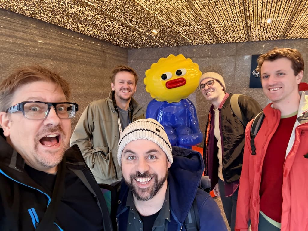 Group of people plus a statue outside the Fairmont hotel. Boris, open mouth, Nick center, Daniel and Fig behind either side of yellow head statue, Bryan at right.