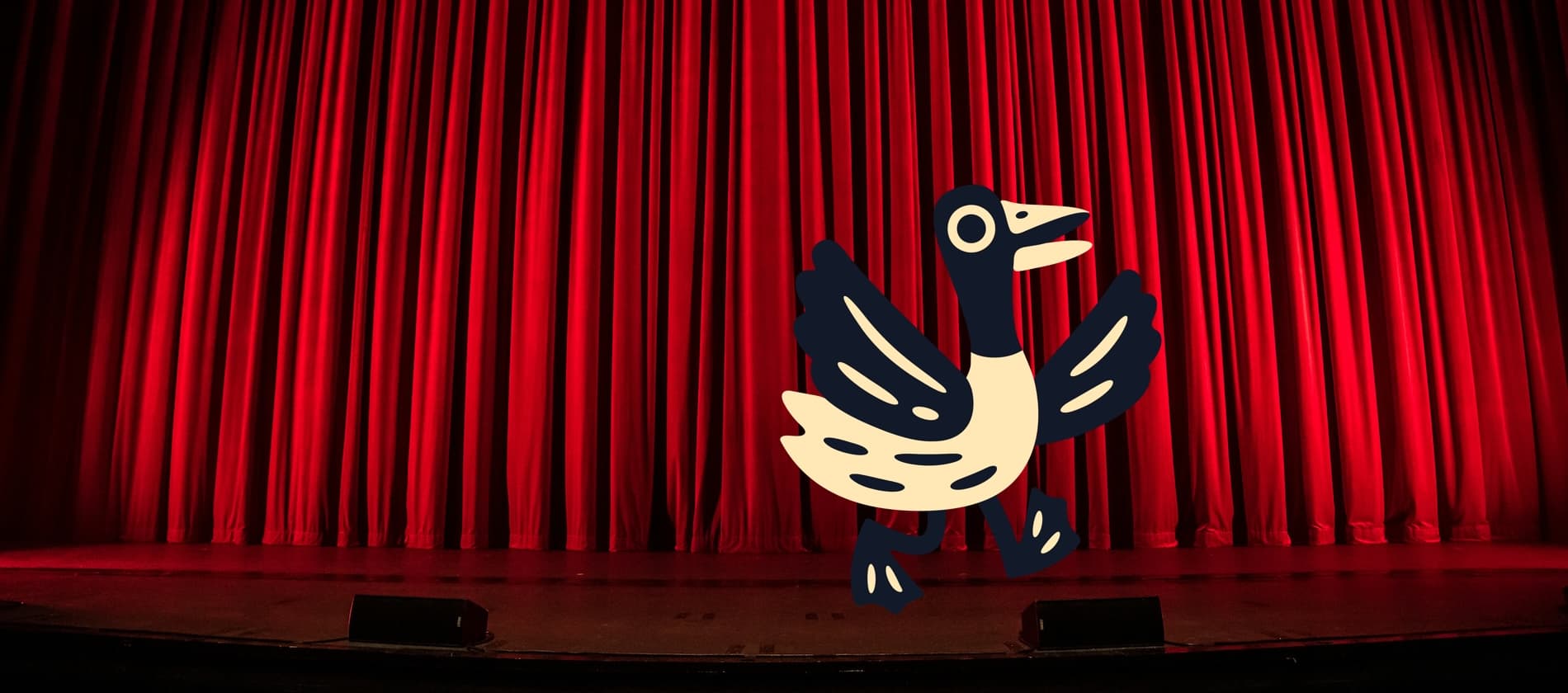 Gustopher is on stage in front of a red curtain