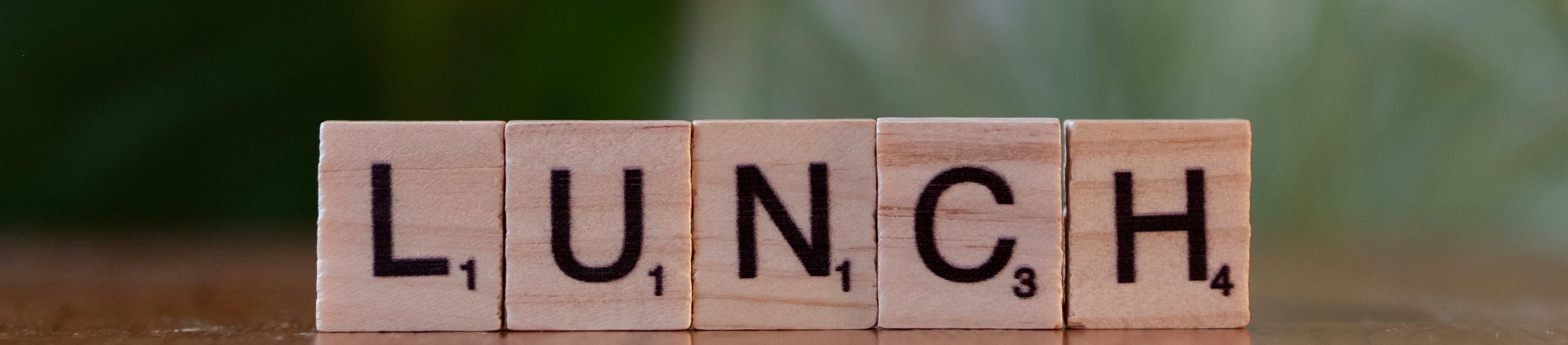 Scrabble tiles spelling LUNCH stand on their thin edge.

Photo by Markus Winkler from Unsplash.