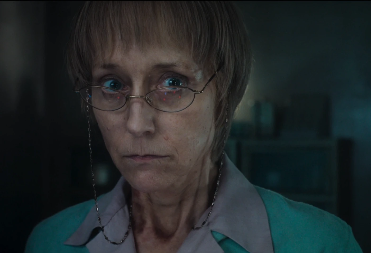 Dr Cooper, interprétée par Lia Williams, dans l'épisode "Sans Issue"
Femme blanche d'une cinquantaine d'années, aux cheveux blonds grisonnants et courst, aux yeux bleus, au visage maigre, portant des lunettes ovales avec un cordon métallisé pendant sur les côtés sous les yeux, elle porte une veste bleu turquoise d'où s'échappe un chemisier mauve. Elle a les traits tendus qui trahissent une indécision de sa part.
On aperçoit diverses armoires et ustensiles en arrière plan, suggérant que l'on se situe bien dans un laboratoire.