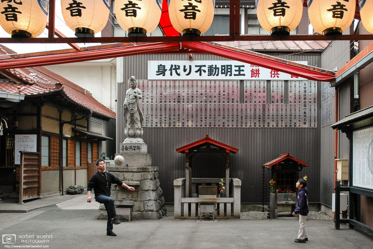 At a temple in the Osu district of Nagoya, Japan, a father and his son are playing football. © 2006 Norbert Woehnl Photography.