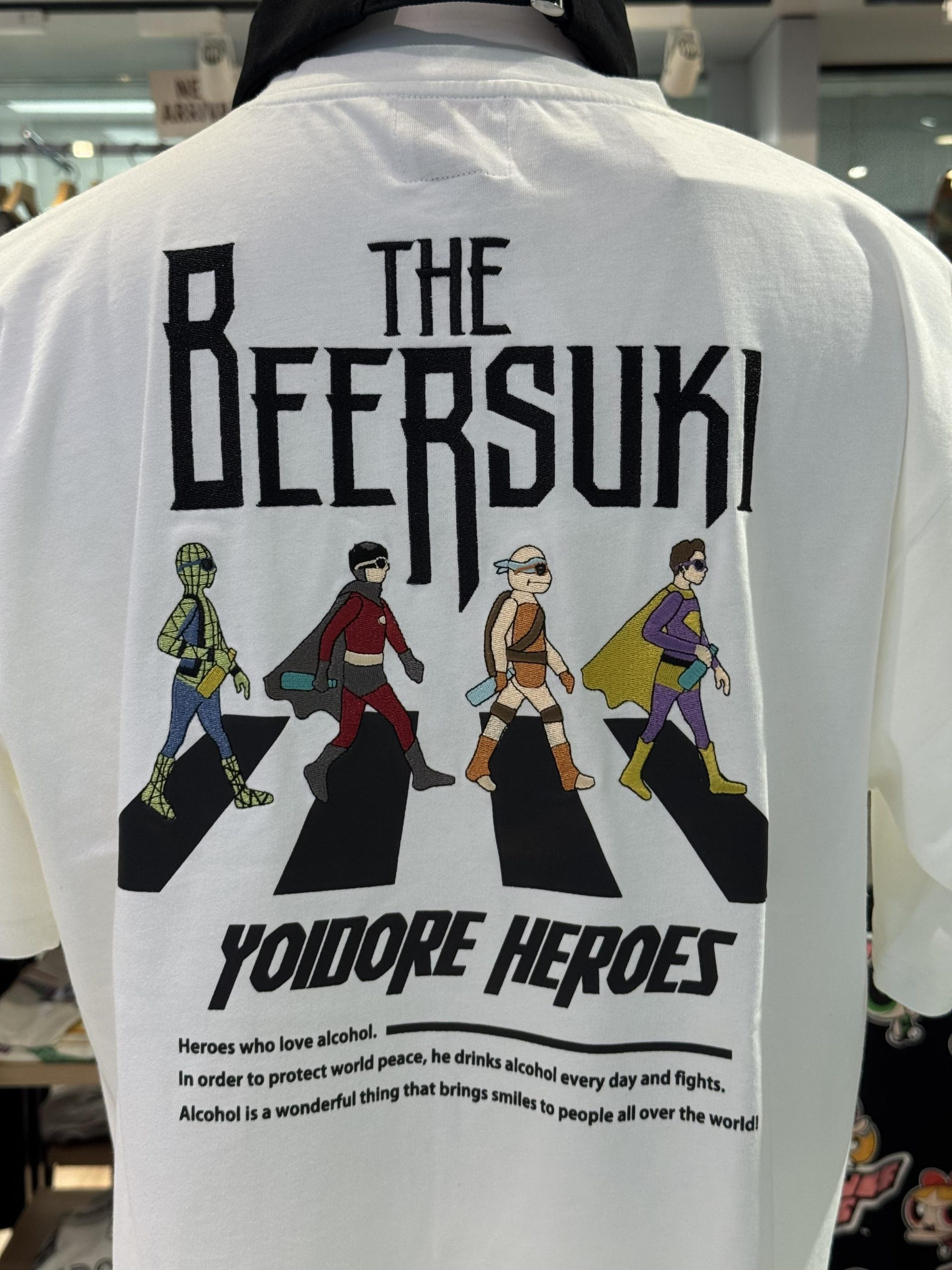 I saw this t-shirt. The image is “inspired by” the Abbey Road cover, showing four superhero-styled colorful characters walking across a zebra crossing. The title is “The Beersuki” (approximately “the beer-lovers”). “Yoidore” means “drunk”. And then, the inspirational inscription at the bottom: “Heroes who love alcohol. In order to protect world peace, he drinks alcohol every day and fights. Alcohol is a wonderful thing that brings smiles to people all over the world!”. © 2026 Norbert Woehnl Photography.