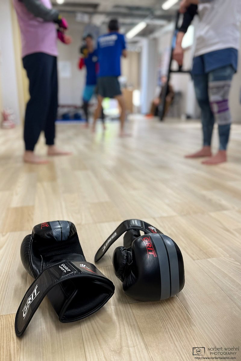 At the kickboxing gym this morning, before wearing my gloves for the sandbag punching practice, I captured this discreet action shot of some other members. © 2026 Norbert Woehnl Photography.
