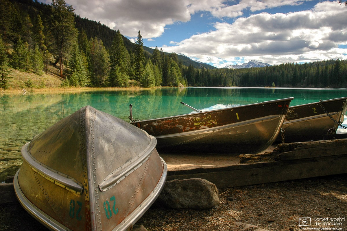 Boats are waiting along a lakeshore in the Valley of Five lakes in Jasper National Park, Alberta, Canada. © 2005 Norbert Woehnl Photography.