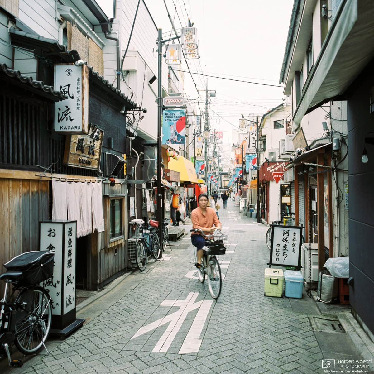 While setting my film camera for a photo along Star Road in the Asagaya area of Tokyo, I saw a bicyclist approaching in the viewfinder - and pushed the shutter. © 2019 Norbert Woehnl Photography.