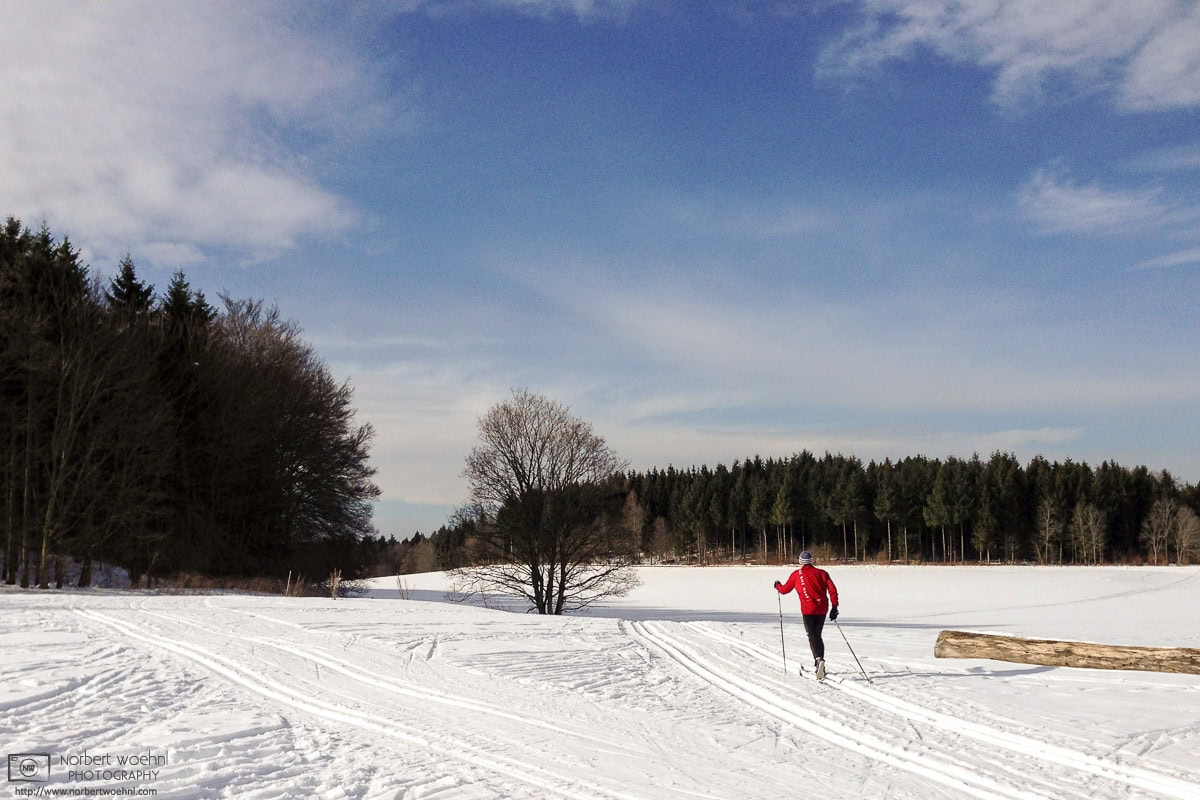 A cross-country skier is enjoying a perfect winter day near the southwest-German village of Sankt Johann on the Swabian Alb. © 2015 Norbert Woehnl Photography.