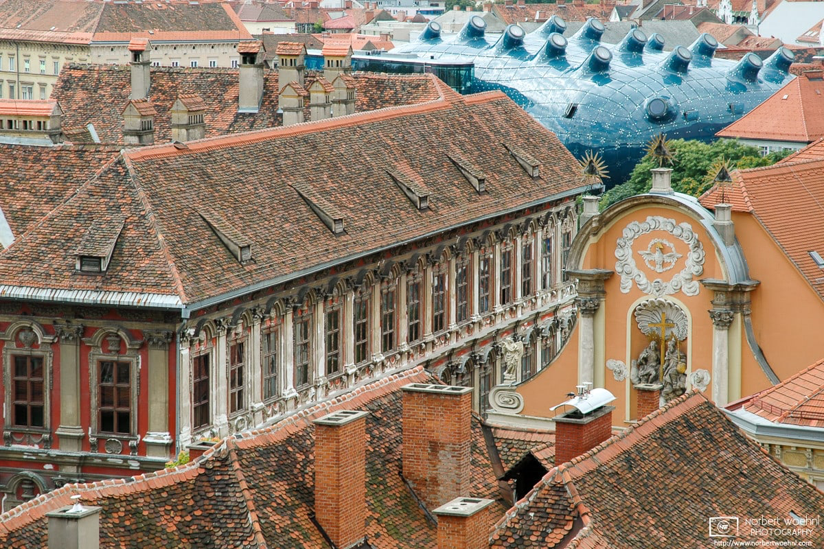 The modern architecture of the Kunsthaus (House of Art) stands out amidst the classic roofscape in the historic city center of Graz, Austria. © 2004 Norbert Woehnl Photography.