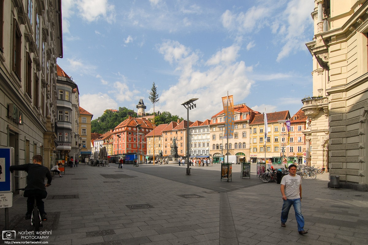 Hauptplatz (Central Square) in the historic city center of Graz, Austria, with a view of the Uhrturm (Clock Tower) - the landmark of Graz - on top of Schlossberg hill. © 2009 Norbert Woehnl Photography.