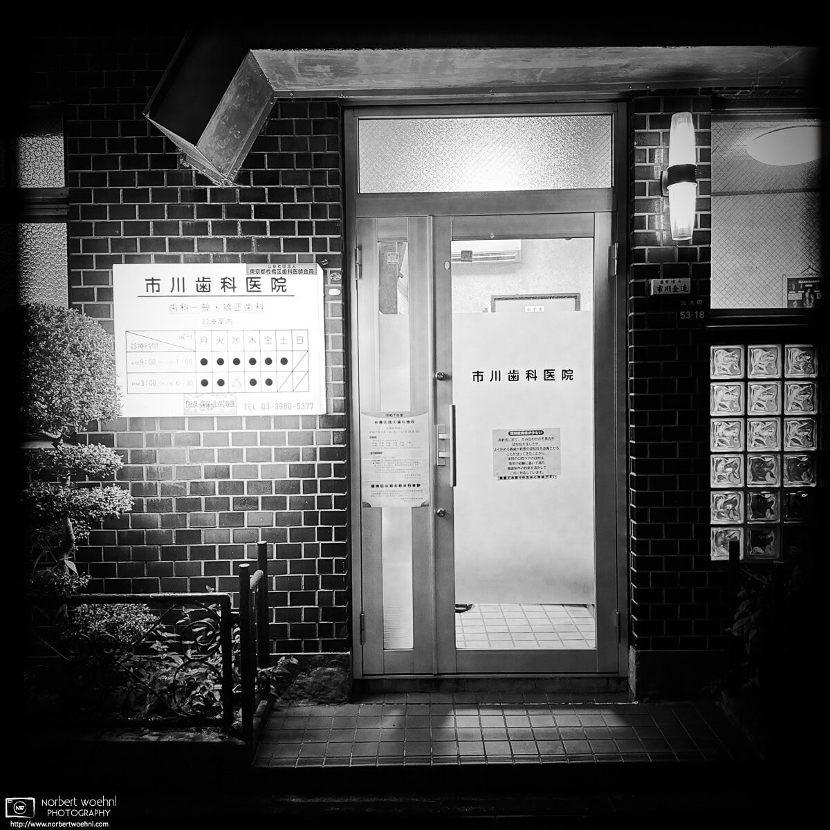 Monochrome evening scene (clinic entrance) from a residential area in the Miyamotocho area of Itabashi Ward in Tokyo, Japan. © 2025 Norbert Woehnl Photography.