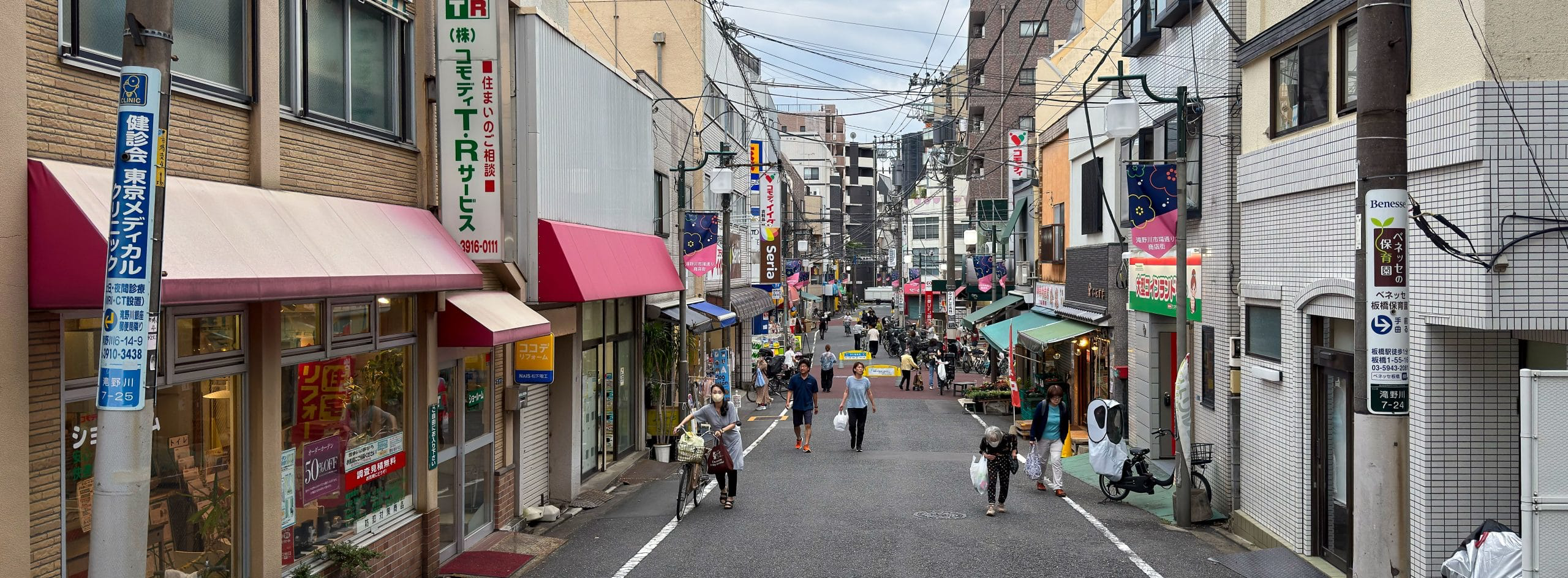 Locals are returning from their errands at a neighborhood shopping street in the Takinogawa area of Kita Ward in Tokyo, Japan. © 2025 Norbert Woehnl Photography.