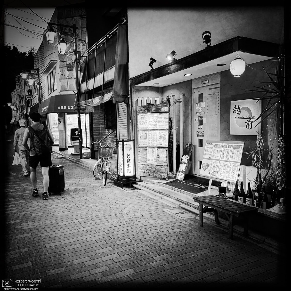 Monochrome evening scene from Inari-dori Shopping Street in the Miyamotocho area of Itabashi Ward in Tokyo, Japan. © 2025 Norbert Woehnl Photography.