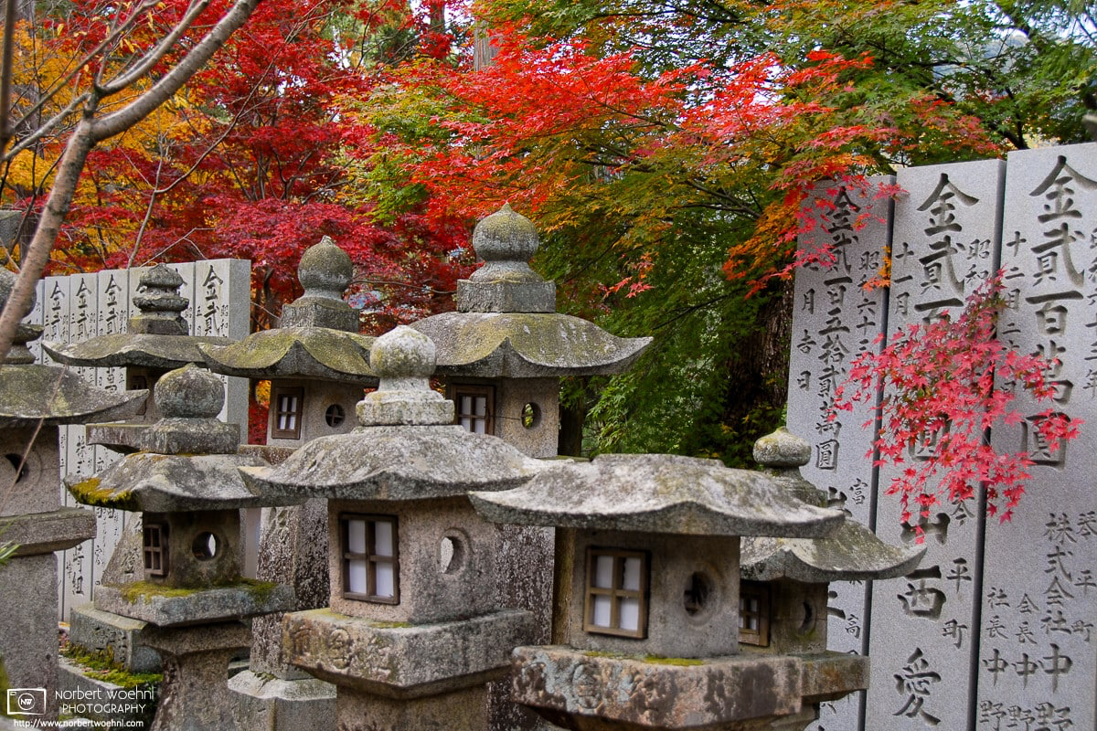 At Konpira-san Shrine in Kotohira on the island of Shikoku, autumnal colors appear around a group of old stone lanterns. © 2006 Norbert Woehnl Photography.