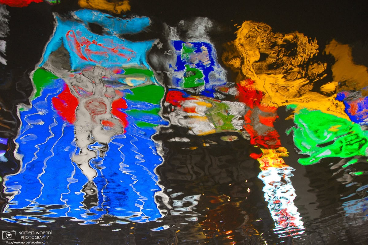 Colorful neon advertisement signs are reflected off the surface of the Dotonbori Canal in Osaka, Japan. © 2010 Norbert Woehnl Photography.