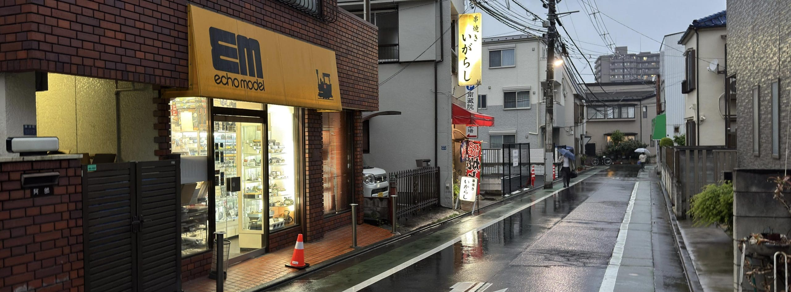 Rainy backstreet evening photo from Itabashi Ward in Tokyo, Japan - model train store and pub. © 2026 Norbert Woehnl Photography.