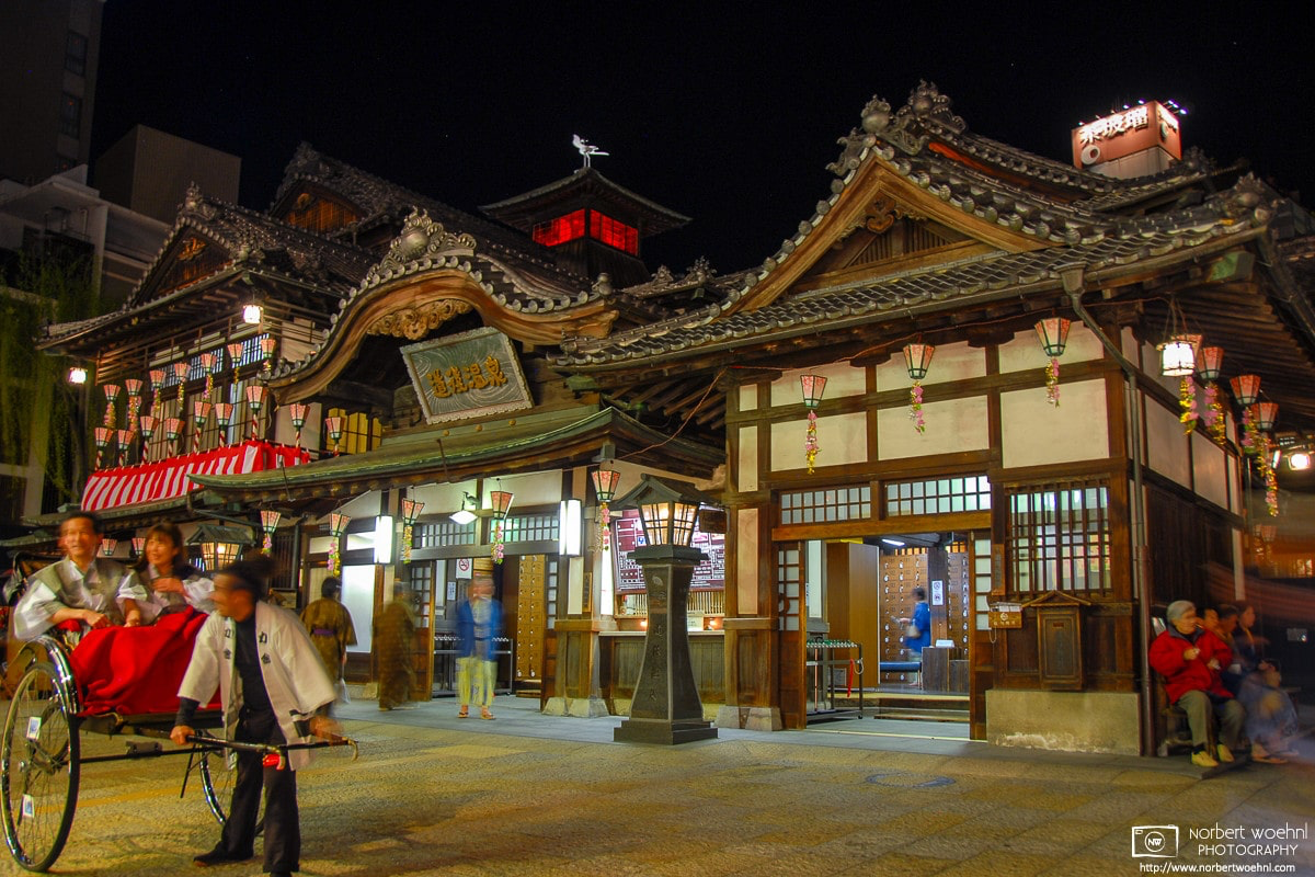 Rickshaw driver and customers on an evening outside Dogo Onsen in Matsuyama on the island of Shikoku, Japan. © 2009 Norbert Woehnl Photography.