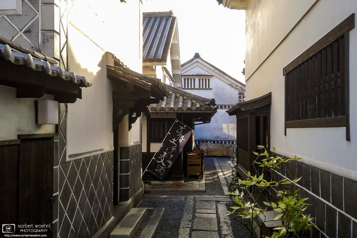 A glimpse between some of the beautiful old warehouse buildings in the Bikan District of Kurashiki, Japan. © 2012 Norbert Woehnl Photography.