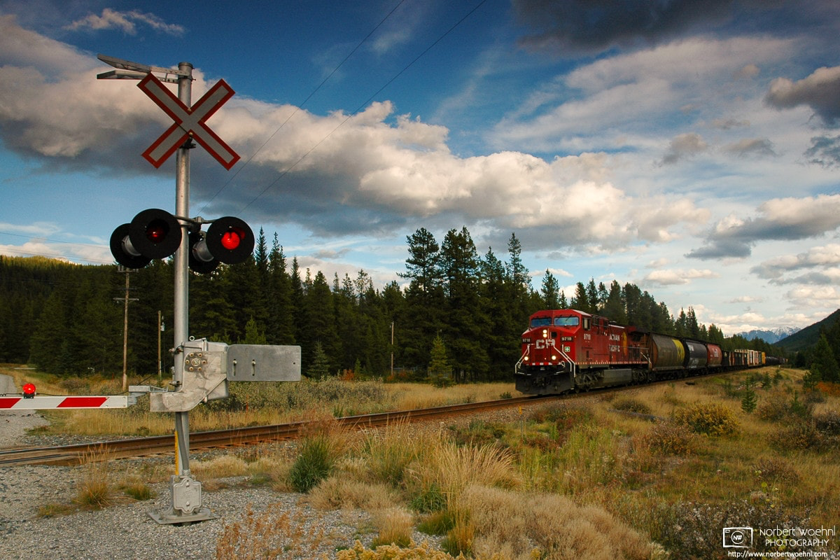 A CPR freight train is arriving at a railway crossing in Banff National Park, Alberta, Canada. © 2005 Norbert Woehnl Photography.