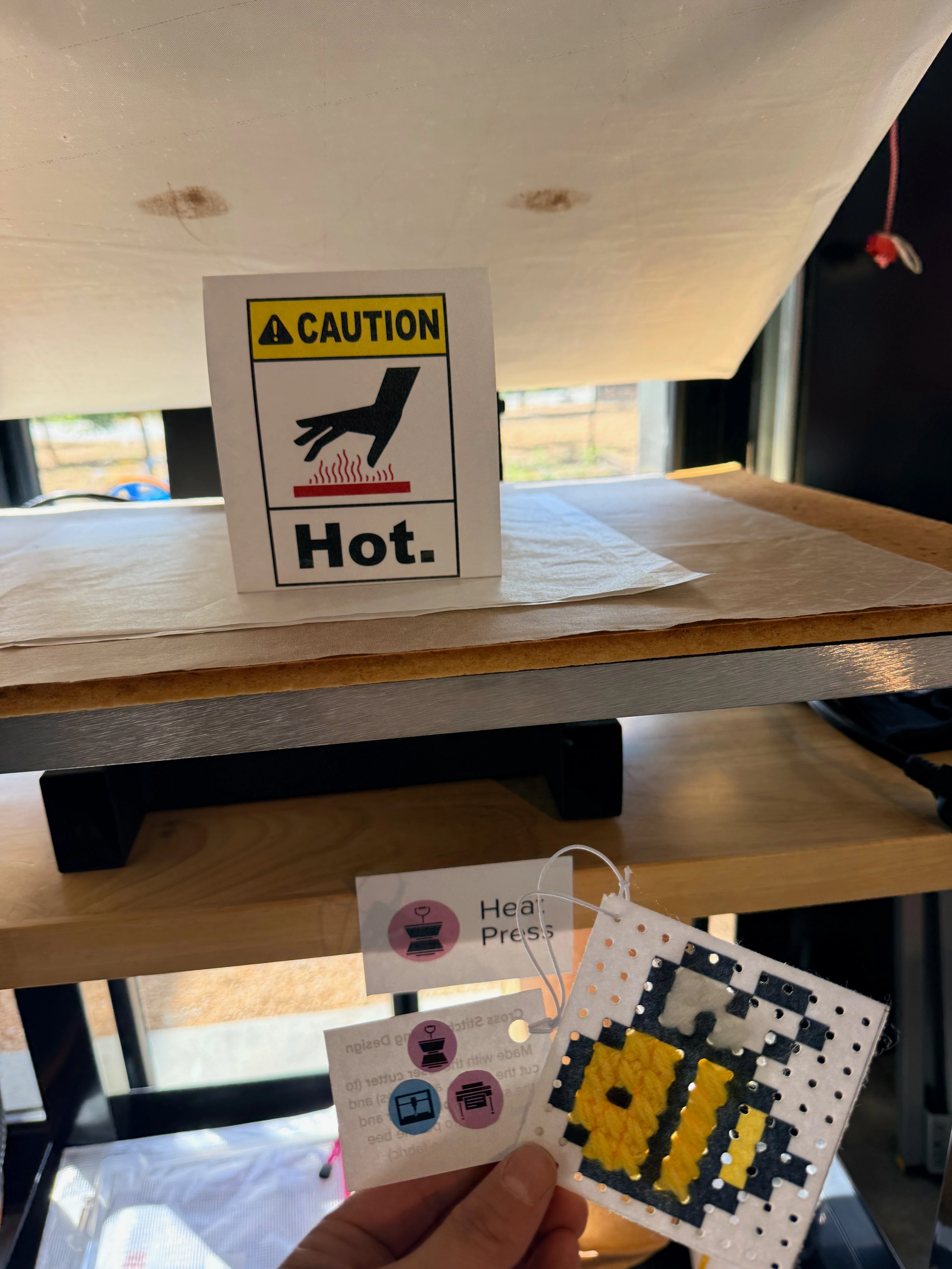 the example is held up in front of the heat press.
